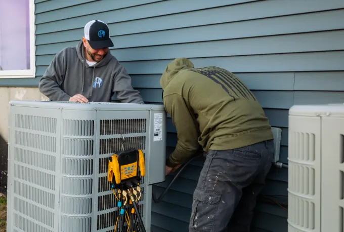Gary Paul Mechanical Technicians working on a AC unit